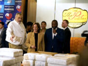 Greg Hatem, owner of The Pit Authentic Barbecue, from left, shows Democratic presidential nominee Vice President Kamala Harris diapers and supplies as visits the restaurant to learn about their relief efforts for Hurricane Helene, in Raleigh, N.C., Saturday.