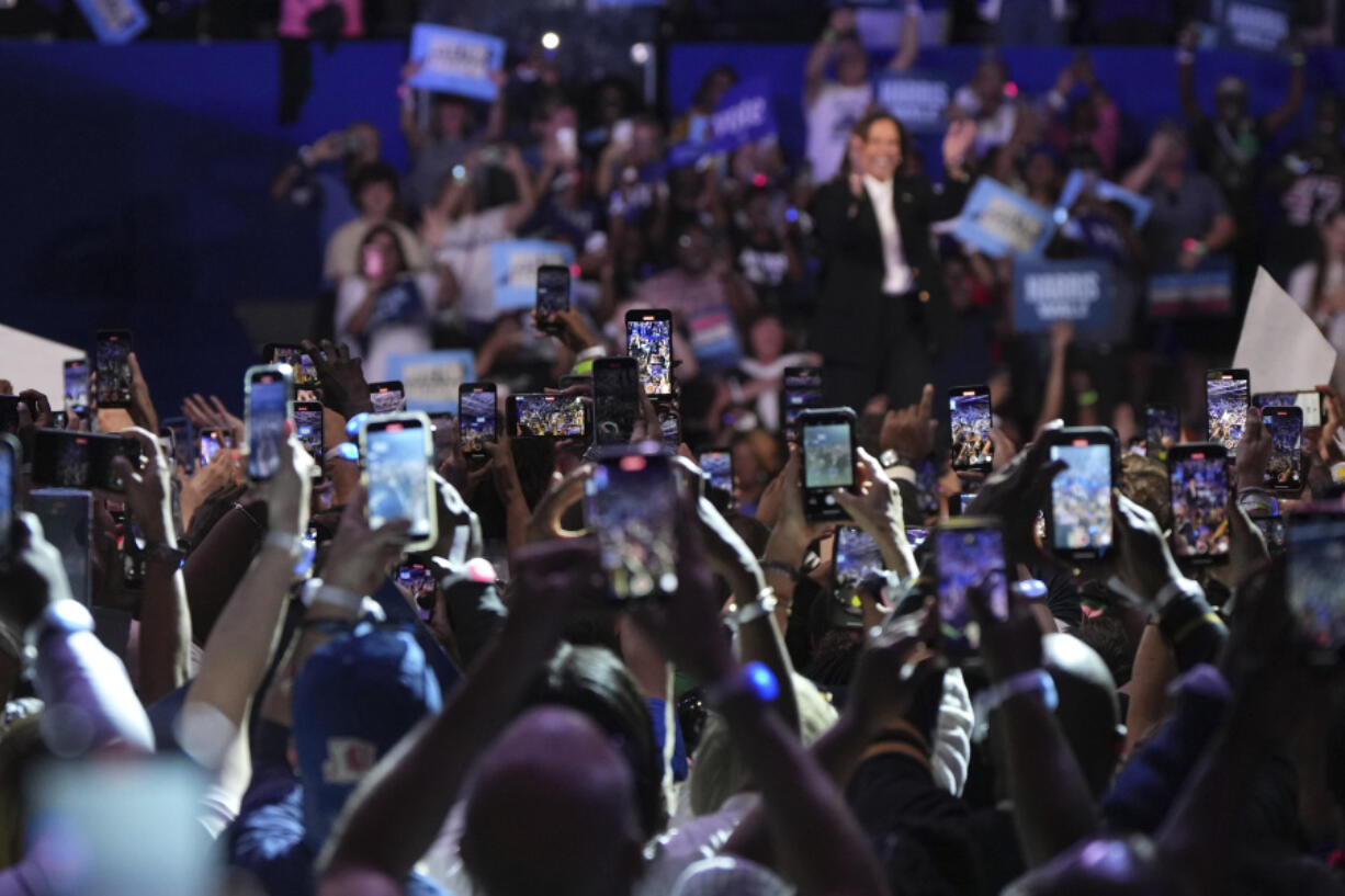 Attendees take photos and record video on their cell phones as Democratic presidential nominee Vice President Kamala Harris speaks during a campaign event at East Carolina University, Sunday, Oct. 13, 2024, in Greenville, N.C.