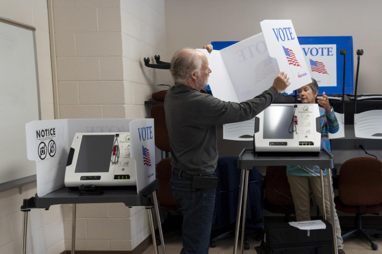 Poll workers set up ballot-marking machines at an early in-person voting site at Asheville-Buncombe Technical Community College, on Oct. 16, 2024, in Marshall, N.C.