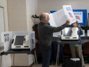 Poll workers set up ballot-marking machines at an early in-person voting site at Asheville-Buncombe Technical Community College, on Oct. 16, 2024, in Marshall, N.C.