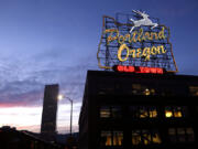 FILE - The &ldquo;Portland, Oregon&rdquo; sign is illuminated in with the Wells Fargo Center building in the background in downtown Portland, Ore., Jan. 27, 2015.