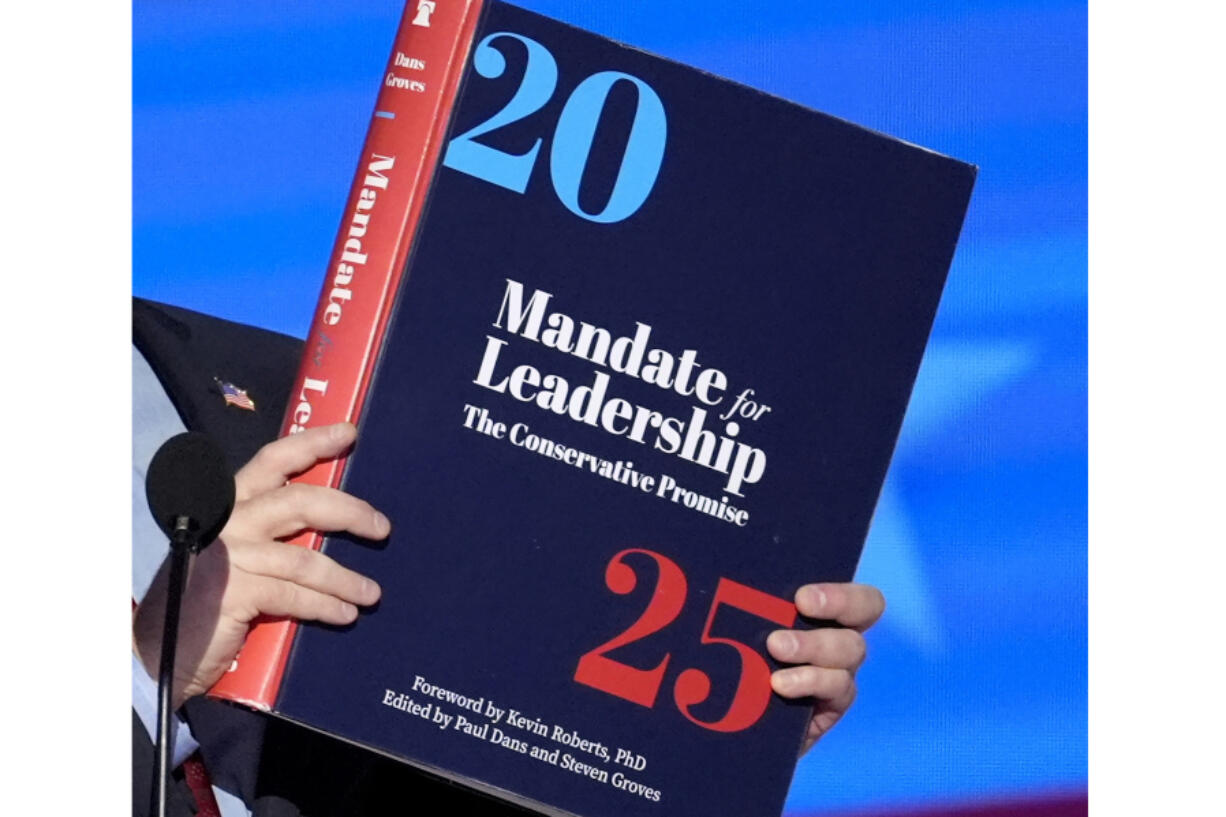 A copy of Project 2025 is held during the Democratic National Convention, Aug. 21, 2024, in Chicago. For a year, Project 2025 has endured as a persistent force in the presidential election. It&rsquo;s rare for a complex 900-page policy book to figure so dominantly in a political campaign. (AP Photo/J.