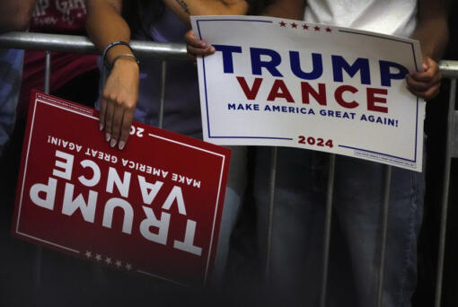 Supporters hold signs as they arrive before Republican presidential nominee former President Donald Trump at a campaign rally at Minges Coliseum, Monday, Oct. 21, 2024, in Greenville, N.C.