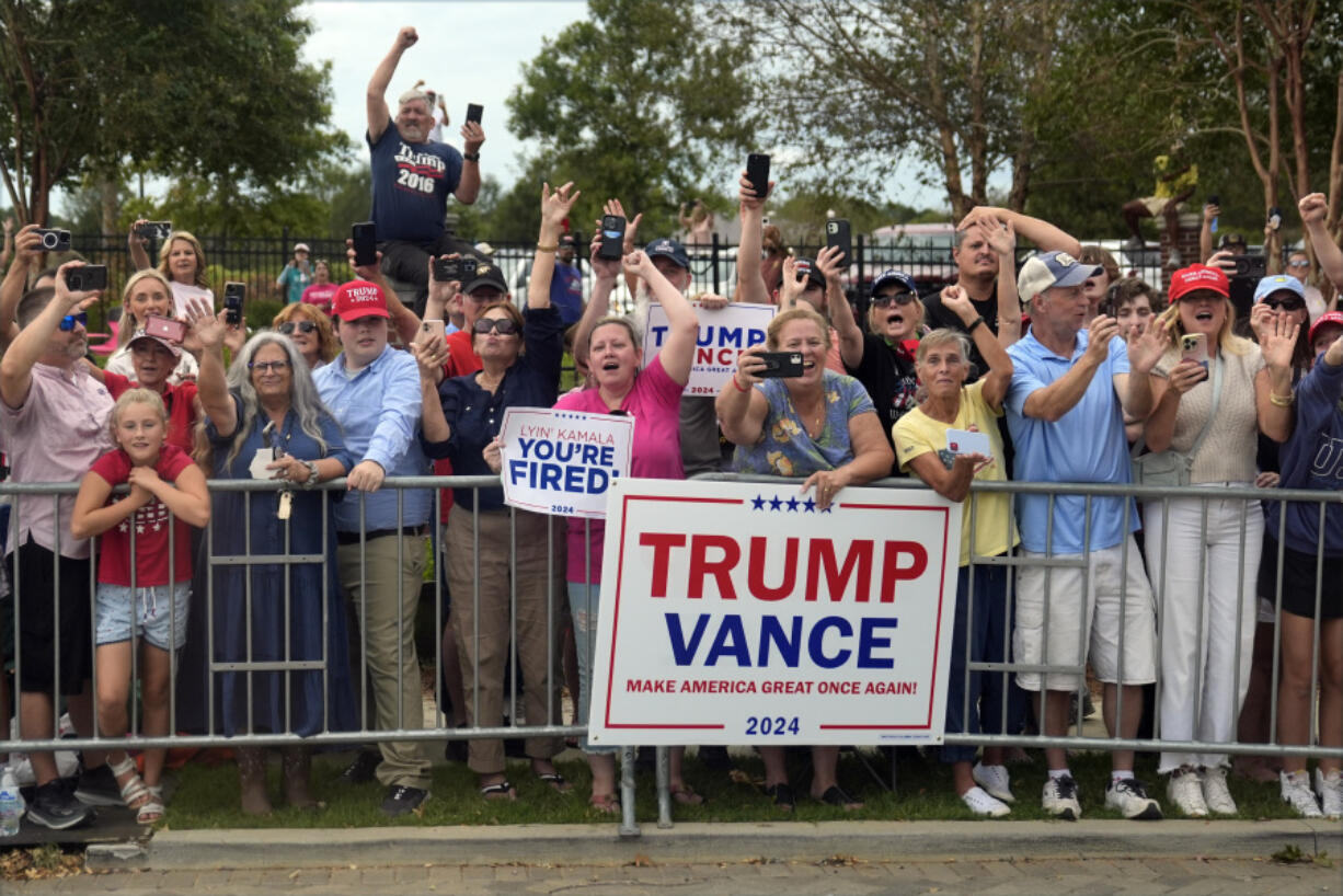 People line the road as Republican presidential nominee former President Donald Trump arrives to speak at a temporary relief shelter as he visits areas impacted by Hurricane Helene, Friday, Oct. 4, 2024, in Evans, Ga.