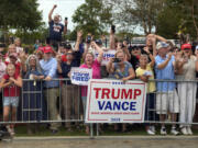 People line the road as Republican presidential nominee former President Donald Trump arrives to speak at a temporary relief shelter as he visits areas impacted by Hurricane Helene, Friday, Oct. 4, 2024, in Evans, Ga.