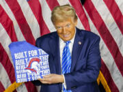 Republican presidential nominee former President Donald Trump shows off a t-shirt given to him by students at a campaign event Tuesday, Oct. 1, 2024, at Discovery World in Milwaukee.