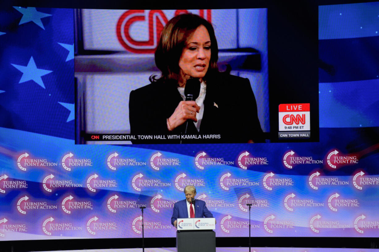 A video plays of Democratic presidential nominee Vice President Kamala Harris speaking during a town hall as Republican presidential nominee former President Donald Trump listens during a campaign rally at Thomas &amp; Mack Center, Thursday, Oct. 24, 2024, in Las Vegas.