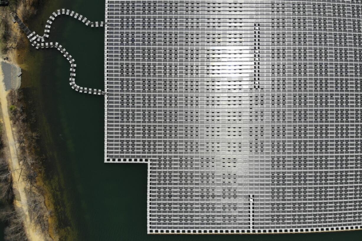 FILE - An array of solar panels float on top of a water storage pond in Sayreville, N.J., April 10, 2023.