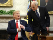 FILE - White House Chief of Staff John Kelly, right, leans in to talk with President Donald Trump in the Oval Office of the White House in Washington, June 27, 2018.