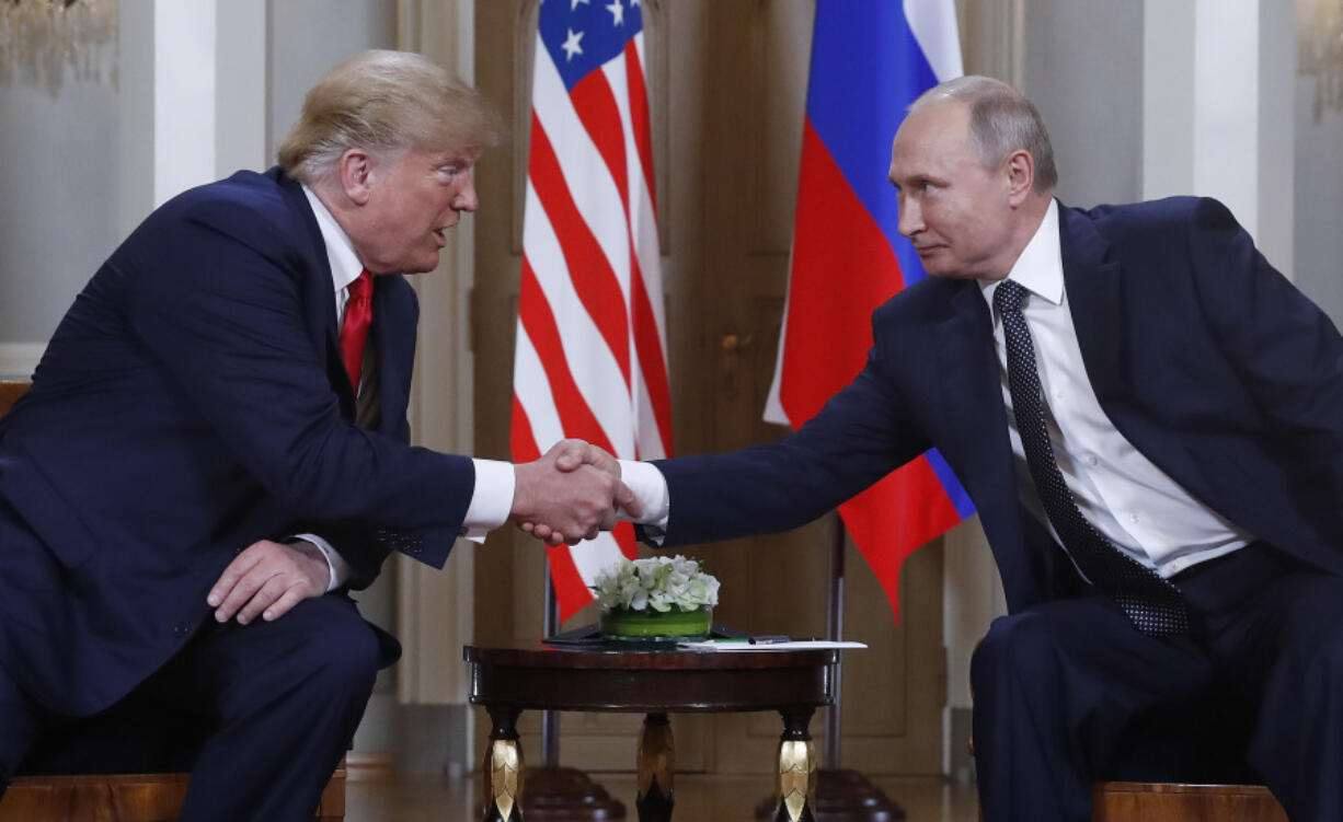 FILE - U.S. President Donald Trump, left, and Russian President Vladimir Putin, right, shake hands at the beginning of a meeting at the Presidential Palace in Helsinki, Finland, July 16, 2018.