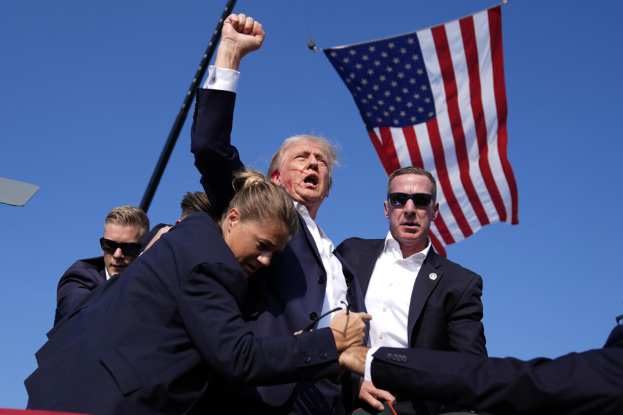 FILE - Republican presidential candidate former President Donald Trump is surrounded by U.S. Secret Service agents at a campaign rally, July 13, 2024, in Butler, Pa.