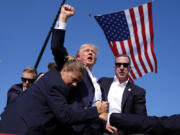 FILE - Republican presidential candidate former President Donald Trump is surrounded by U.S. Secret Service agents at a campaign rally, July 13, 2024, in Butler, Pa.