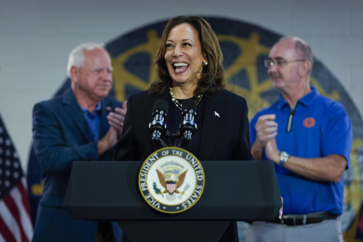 FILE - Democratic presidential nominee Vice President Kamala Harris, with Democratic vice presidential nominee Minnesota Gov. Tim Walz, left, and UAW President Shawn Fain, speaks at a campaign rally at UAW Local 900, Aug. 8, 2024, in Wayne, Mich.