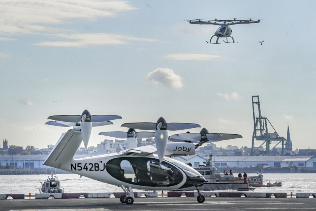 FILE - An electric vertical takeoff and landing (eVTOL) aircraft, flies above the Joby eVTOL aircraft, during a demonstration of eVTOLs Nov. 13, 2023, in New York.