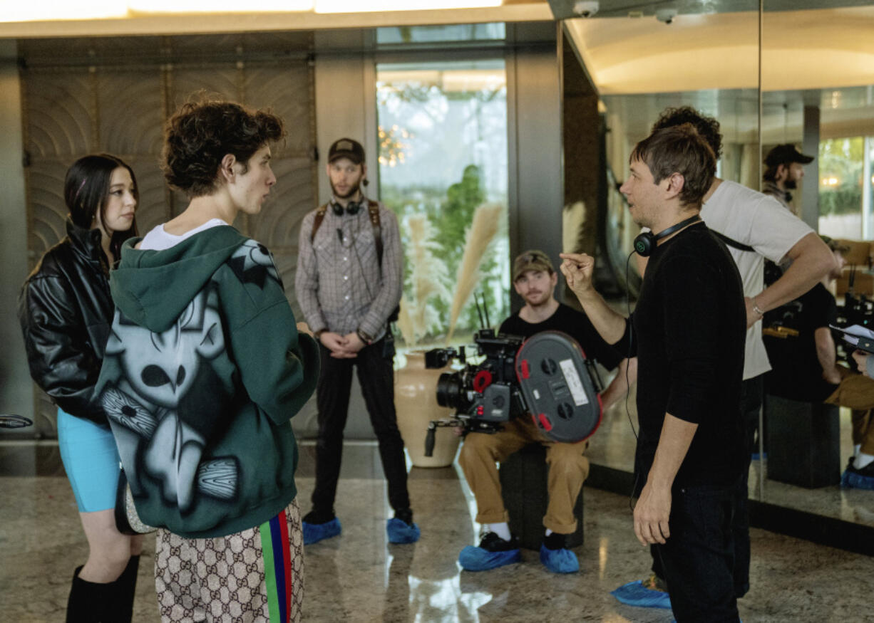 Mikey Madison, left, and Mark Eydelshteyn, second left, with director Sean Baker, right, on the set of  &ldquo;Anora.&rdquo; (Augusta Quirk/Neon)