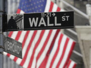 FILE - Signs marking the intersection of Broad and Walls Streets appear near the New York Stock Exchange on Oct. 1, 2024, in New York.