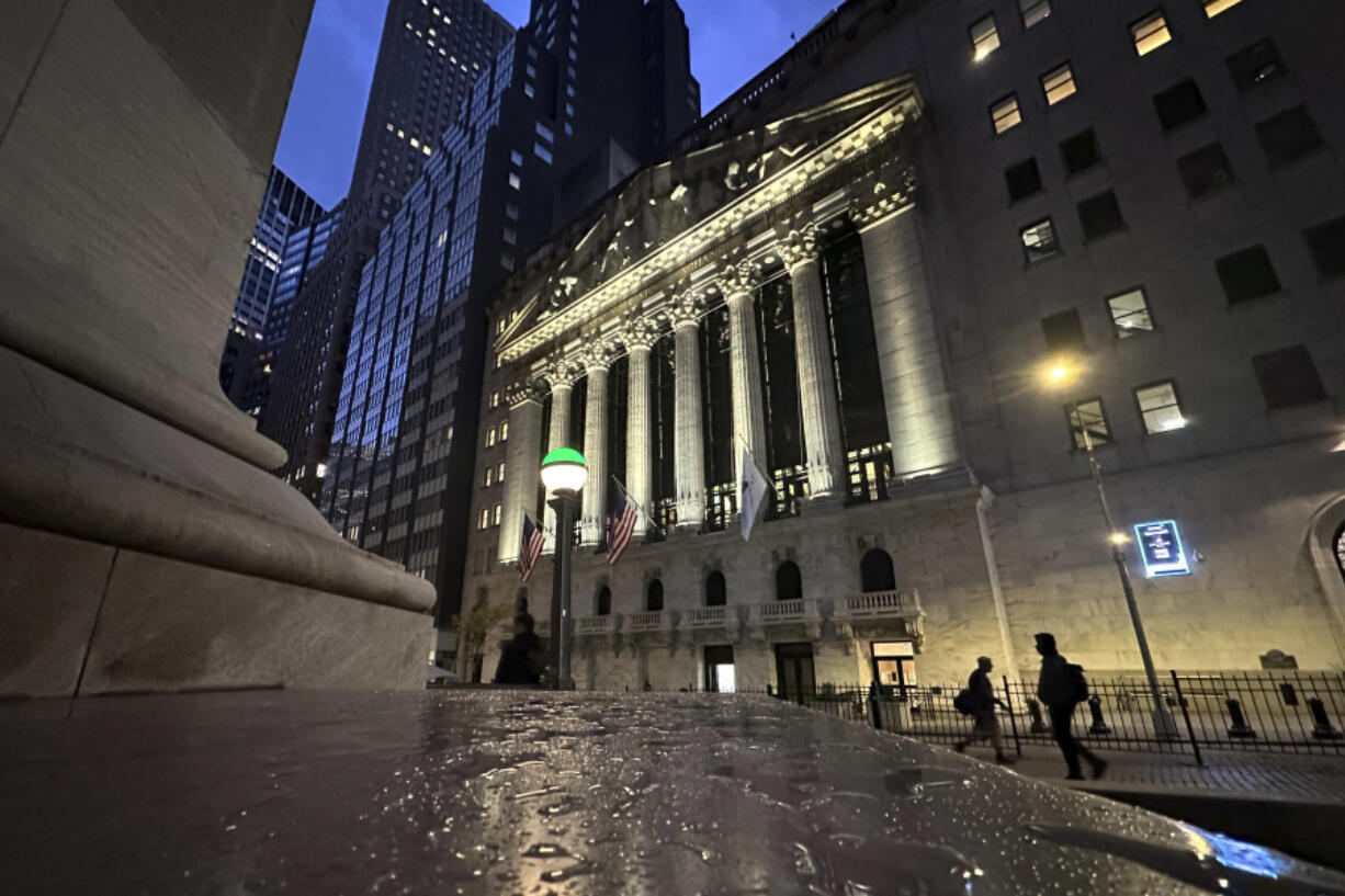 People pass the New York Stock Exchange early Tuesday, Oct. 29, 2024.