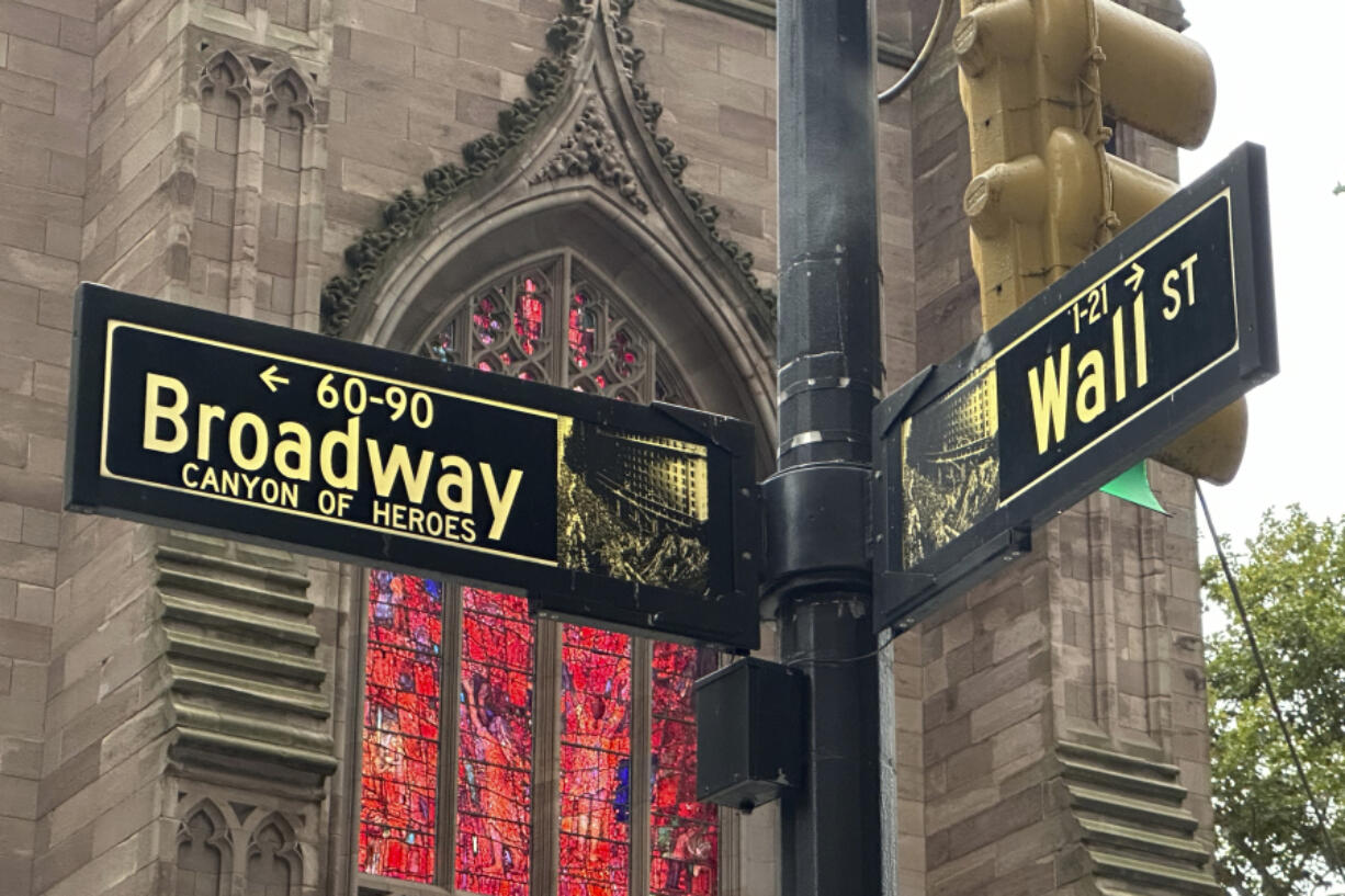 FILE - Signs mark the intersection of Broadway and Wall Street in the Financial District on Oct. 2, 2024, in New York. Trinity Church is in the background.