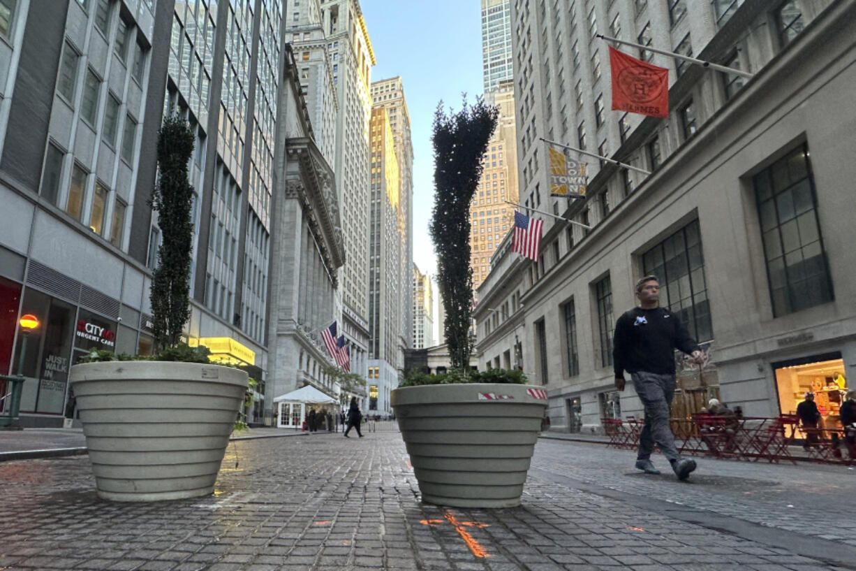 FILE - People pass the New York Stock Exchange, at rear, in New York&rsquo;s Financial District on Oct. 16, 2024.