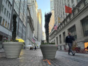 FILE - People pass the New York Stock Exchange, at rear, in New York&rsquo;s Financial District on Oct. 16, 2024.