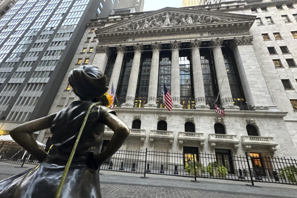 FILE - The Fearless Girl statue, with a flower draped on the shoulder, stands outside the New York Stock Exchange on Oct. 23, 2024.