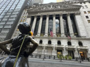 FILE - The Fearless Girl statue, with a flower draped on the shoulder, stands outside the New York Stock Exchange on Oct. 23, 2024.