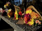 Bouquets of flowers line a stone picnic table at a roadside park as a small memorial to the victims of a mass shooting the day before in Fall City, Wash., Tuesday, Oct. 22, 2024.