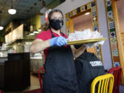 File - A waitress works at a restaurant in Chicago on March 23, 2023. (AP Photo/Nam Y.