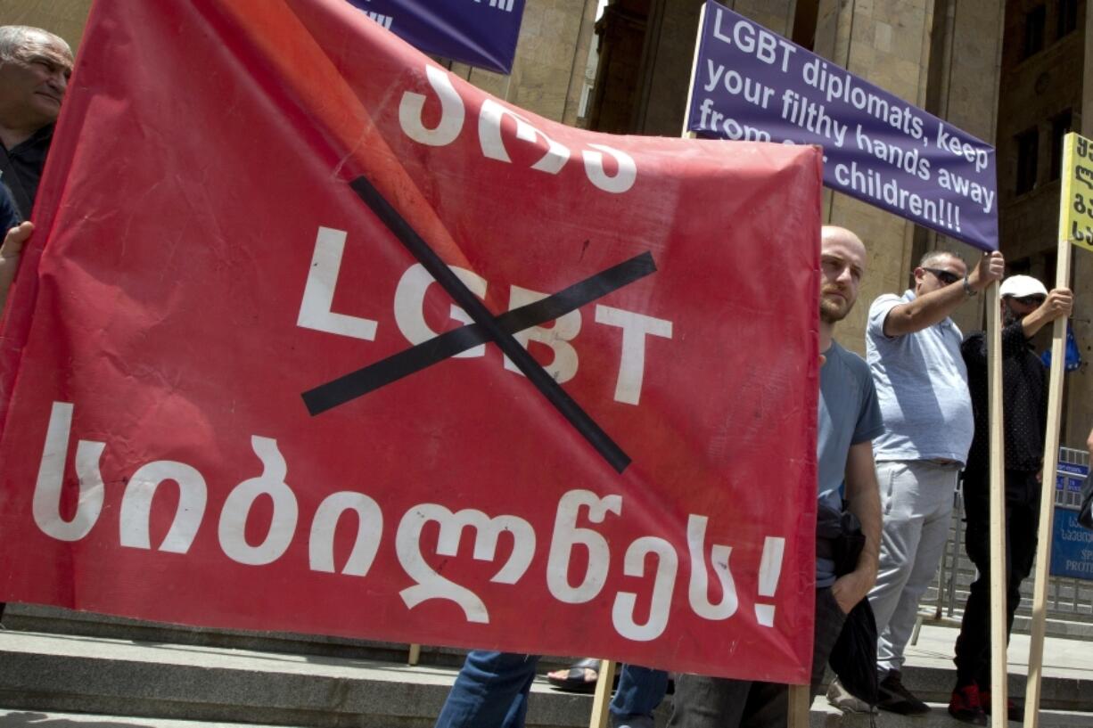 FILE - Georgian far right parties and their supporters hold a banner that reads: &ldquo;No to LGBT darkness,&rdquo; in front of the parliament during a rally against Pride Week in Tbilisi, Georgia, on July 2, 2022.