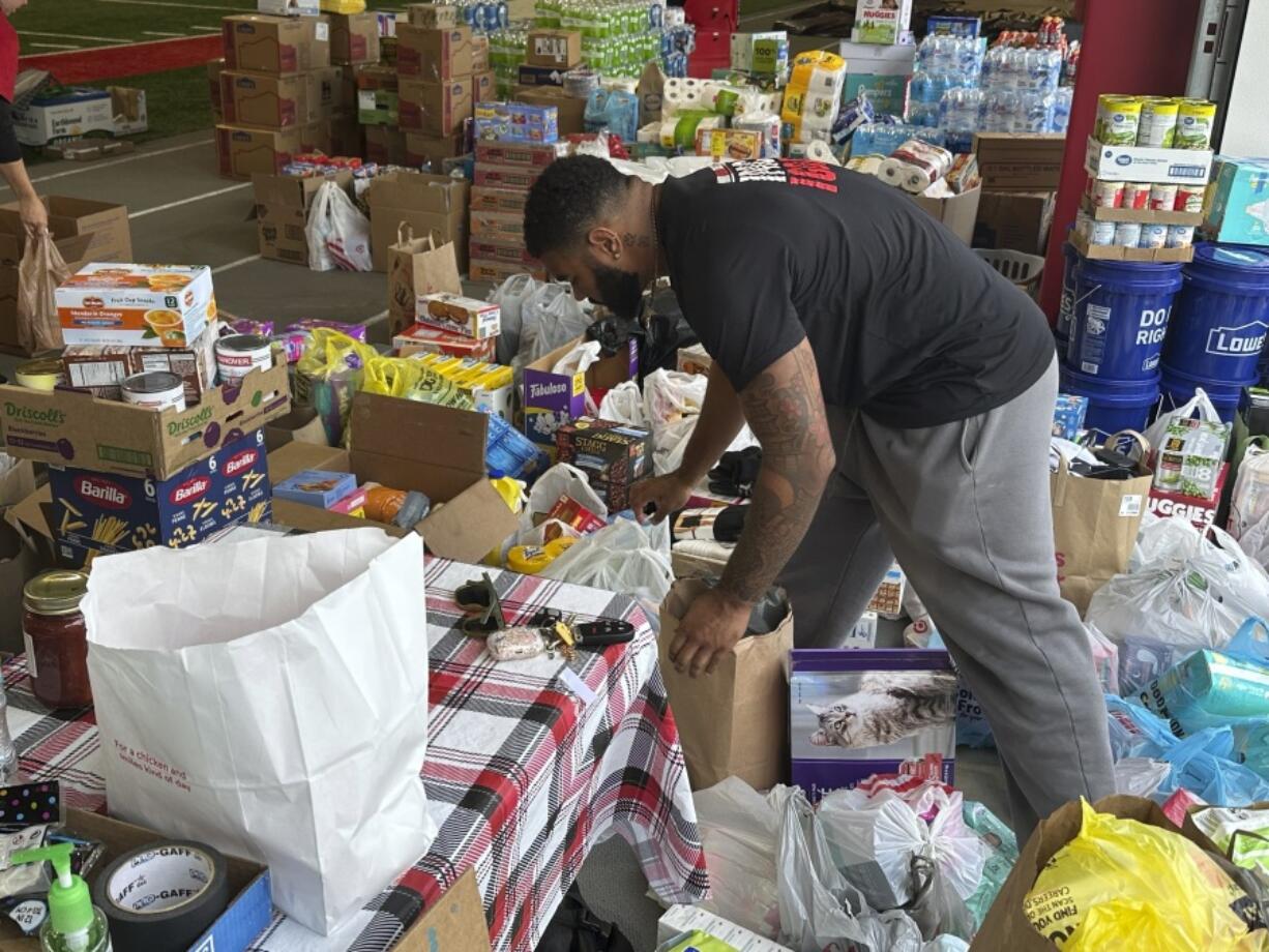 FILE - N.C. State defensive end Davin Vann works among the donations collected to help Hurricane Helene victims in western North Carolina, Oct. 2, 2024 in Raleigh, N.C.