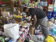 FILE - N.C. State defensive end Davin Vann works among the donations collected to help Hurricane Helene victims in western North Carolina, Oct. 2, 2024 in Raleigh, N.C.