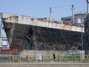 FILE - A person runs past the S.S. United States moored on the Delaware River in Philadelphia, Sept. 4, 2024.