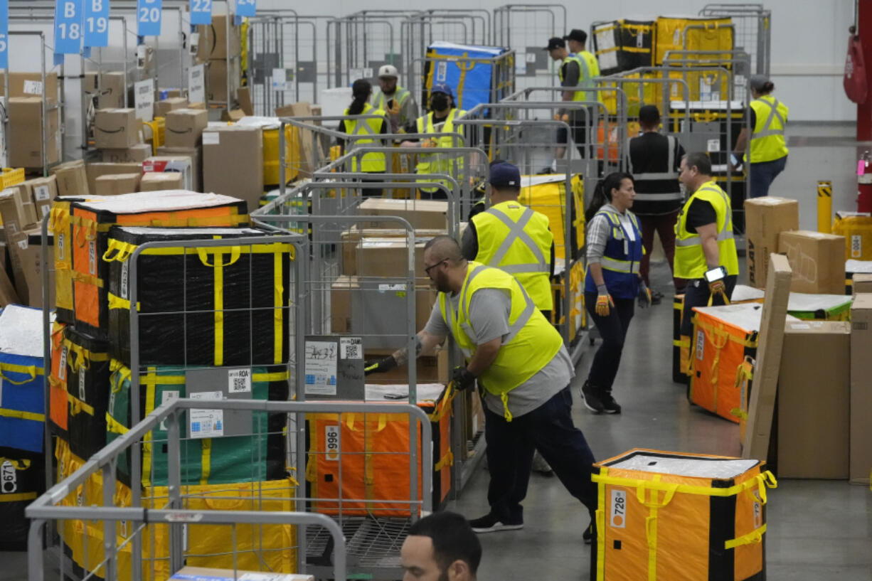 FILE - Amazon employees load packages on carts before being put on to trucks for distribution to customers for Amazon&rsquo;s annual Prime Day event at an Amazon&rsquo;s DAX7 delivery station on July 16, 2024, in South Gate, Calif.