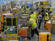 FILE - Amazon employees load packages on carts before being put on to trucks for distribution to customers for Amazon&rsquo;s annual Prime Day event at an Amazon&rsquo;s DAX7 delivery station on July 16, 2024, in South Gate, Calif.