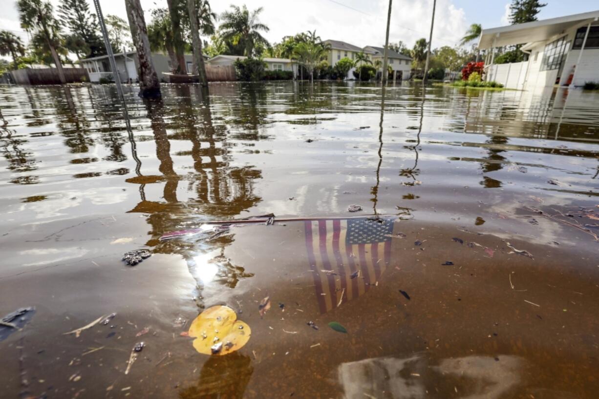 FILE - An American flag sits in floodwaters in the aftermath of Hurricane Helene in the Shore Acres neighborhood Sept. 27, 2024, in St. Petersburg, Fla.