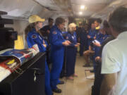 In this image released by the National Oceanic and Atmospheric Administration, a NOAA crew on a reconnaissance flight, Tuesday, Oct. 8, 2024, into the eye of Hurricane Milton in the Gulf of Mexico, gather before dropping a package containing the ashes of Peter Dodge, an award-winning scientist who made almost 400 hundreds flight into the eyes of hurricanes, as a lasting tribute to the longtime radar specialist and researcher.