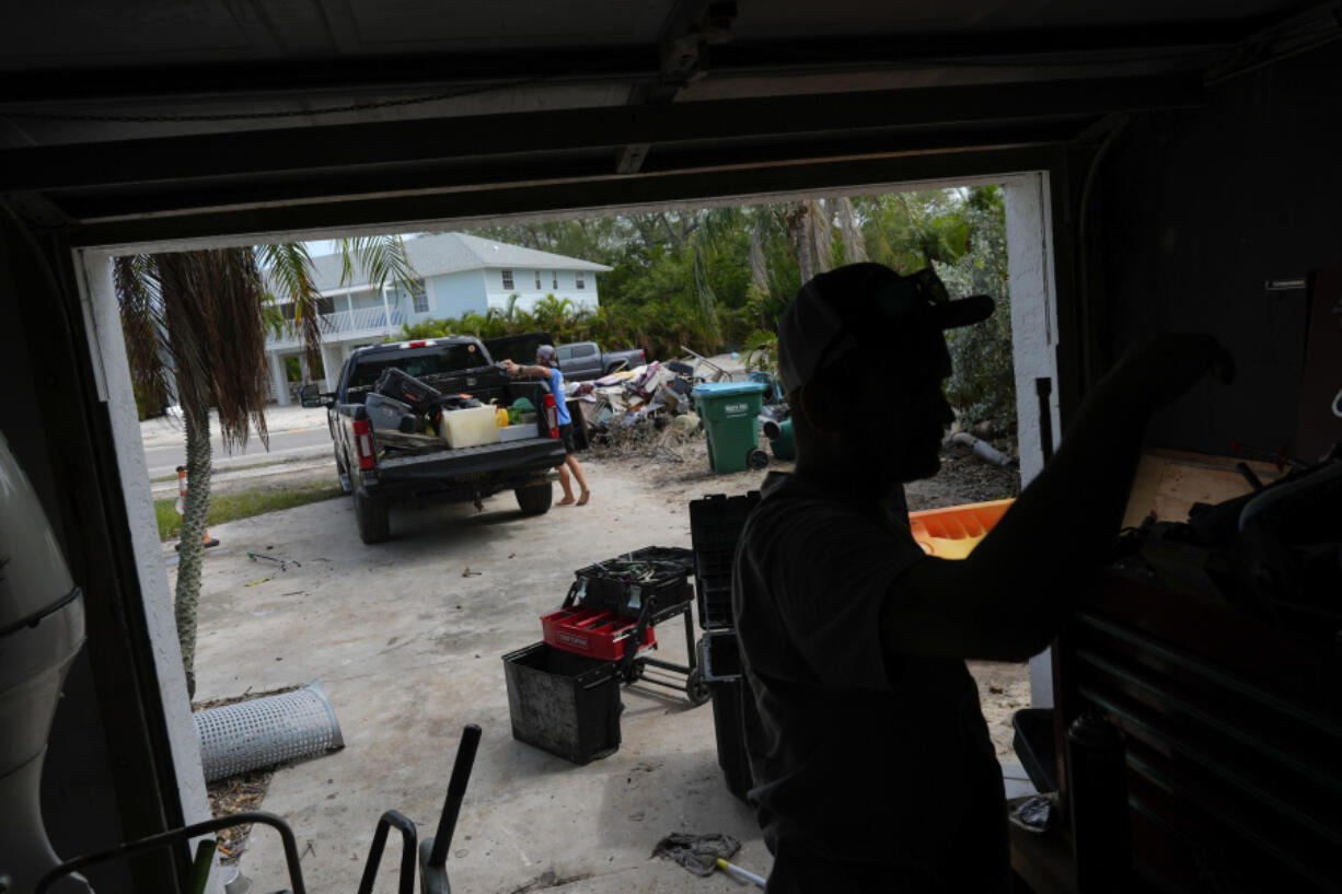 Mechanic Evan Purcell, 43, right, and friend Ted Carlson pack up tools and last-minute items they want to salvage from Purcell&rsquo;s duplex ahead of the arrival of Hurricane Milton, in Holmes Beach on Anna Maria Island, Fla., Tuesday, Oct. 8, 2024. Purcell, who has lived on the island for 40 years, suffered thousands of dollars in damage on his garage level from Hurricane Helene and says it&rsquo;s &ldquo;a coin toss&rdquo; whether his home will still be standing in a few days. &ldquo;I just have a pit in my stomach about this one,&rdquo; he said.