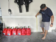 Chris Sundar measures the depth of floodwaters from Hurricane Milton in his garage Sunday, Oct. 13, 2024, in Tampa, Fla.