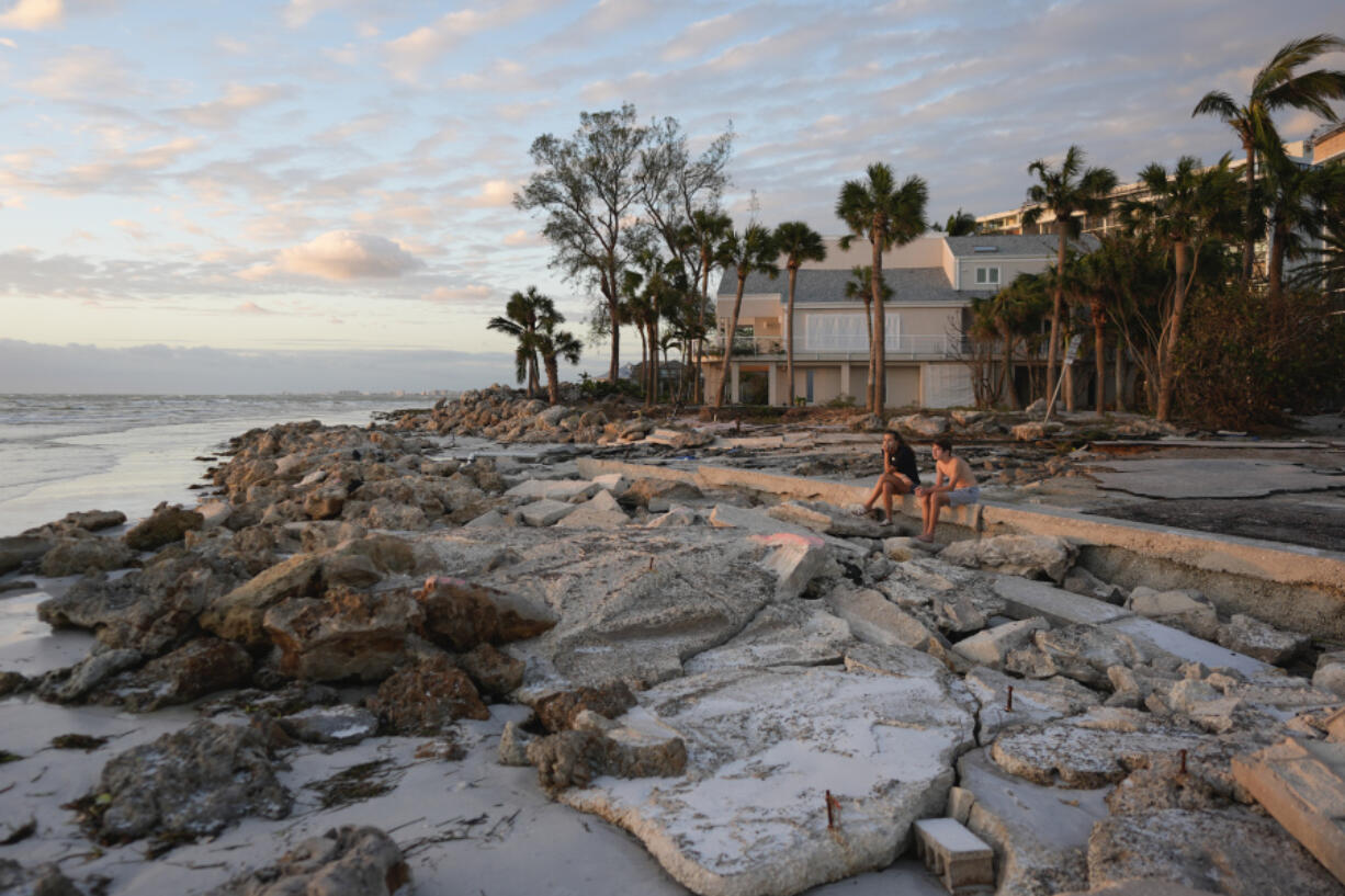 Young people from Sarasota, Fla., visit a familiar beach on Siesta Key, Fla., which they say was already decimated by Hurricane Helene, and lost feet more of sand coverage in Hurricane Milton, Thursday, Oct. 10, 2024.