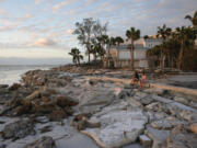 Young people from Sarasota, Fla., visit a familiar beach on Siesta Key, Fla., which they say was already decimated by Hurricane Helene, and lost feet more of sand coverage in Hurricane Milton, Thursday, Oct. 10, 2024.