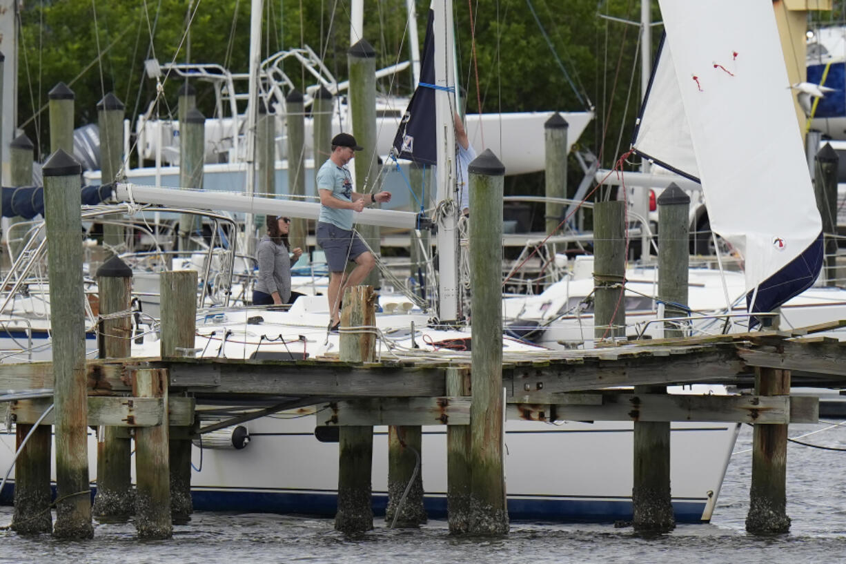 Owners try to secure their boat at the Davis Islands Yacht Clubs ahead a possible landfall by Hurricane Milton, Monday, Oct. 7, 2024, in Tampa, Fla.