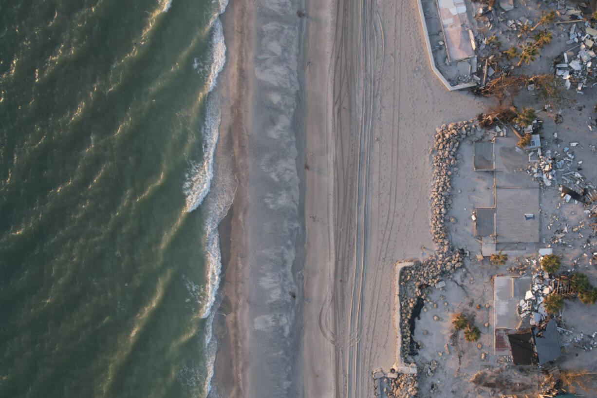 Waves roll in from the Gulf of Mexico toward lots where only empty foundations and debris remain after homes were swept away in Hurricane Milton, on Manasota Key in Englewood, Fla., Sunday, Oct. 13, 2024.