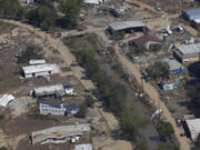 FILE - A view of damage in Asheville, N.C., is seen during an aerial tour with President Joe Biden who looked at areas impacted by Hurricane Helene near Asheville, N.C., Oct. 2, 2024.