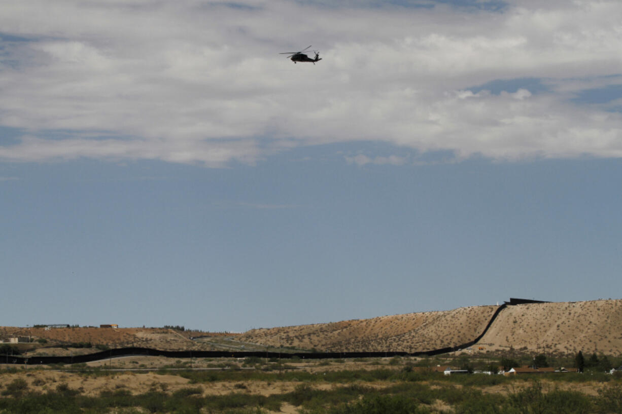 A surveillance helicopter traces a line in the sky above the Southwest border with Mexico at Sunland Park, N.M., Thursday, Aug. 22, 2024.