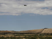 A surveillance helicopter traces a line in the sky above the Southwest border with Mexico at Sunland Park, N.M., Thursday, Aug. 22, 2024.