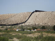 Border Patrol vehicles survey a steel fence at the Southwest border with Mexico at Sunland Park, N.M., Thursday, Aug. 22, 2024.