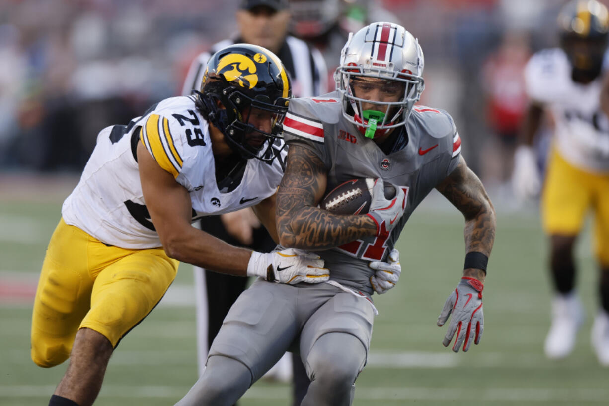 Iowa receiver defensive back Sebastian Castro, left, tackles Ohio State receiver Brandon Inniss during the second half of an NCAA college football game, Saturday, Oct. 5, 2024, in Columbus, Ohio.