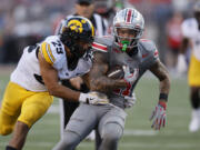 Iowa receiver defensive back Sebastian Castro, left, tackles Ohio State receiver Brandon Inniss during the second half of an NCAA college football game, Saturday, Oct. 5, 2024, in Columbus, Ohio.