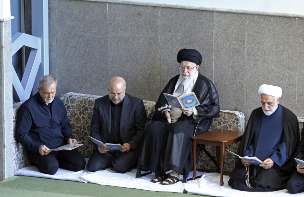 In this photo released by the official website of the office of the Iranian supreme leader, Supreme Leader Ayatollah Ali Khamenei, second right, Judiciary Chief Gholam Hossein Mohseni Ejehei, right, Parliament Speaker Mohammad Bagher Qalibaf, second left, and President Masoud Pezeshkian read Quran in a ceremony commemorating slain Hezbollah leader Hassan Nasrallah, at Imam Khomeini grand mosque in Tehran, Iran, Friday, Oct. 4, 2024.