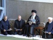 In this photo released by the official website of the office of the Iranian supreme leader, Supreme Leader Ayatollah Ali Khamenei, second right, Judiciary Chief Gholam Hossein Mohseni Ejehei, right, Parliament Speaker Mohammad Bagher Qalibaf, second left, and President Masoud Pezeshkian read Quran in a ceremony commemorating slain Hezbollah leader Hassan Nasrallah, at Imam Khomeini grand mosque in Tehran, Iran, Friday, Oct. 4, 2024.